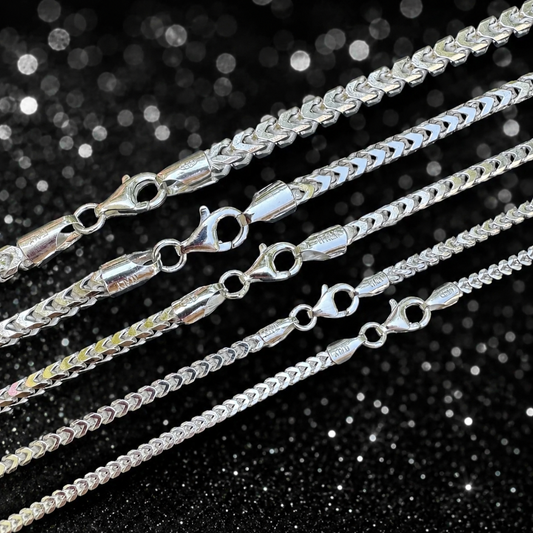Silver chain necklaces on a black glittery background
