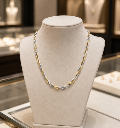 Two-tone gold and silver necklace on a mannequin bust in a jewelry store setting.